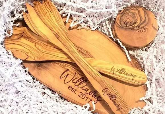 Laser-engraved olive wood kitchenware showing natural grain and custom details