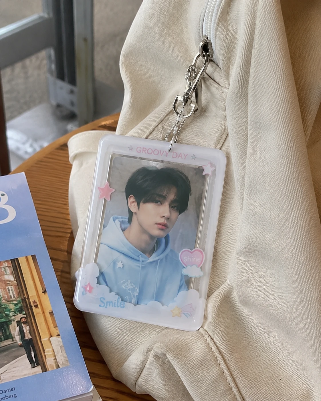 UV printed acrylic photocard holder attached to a beige backpack