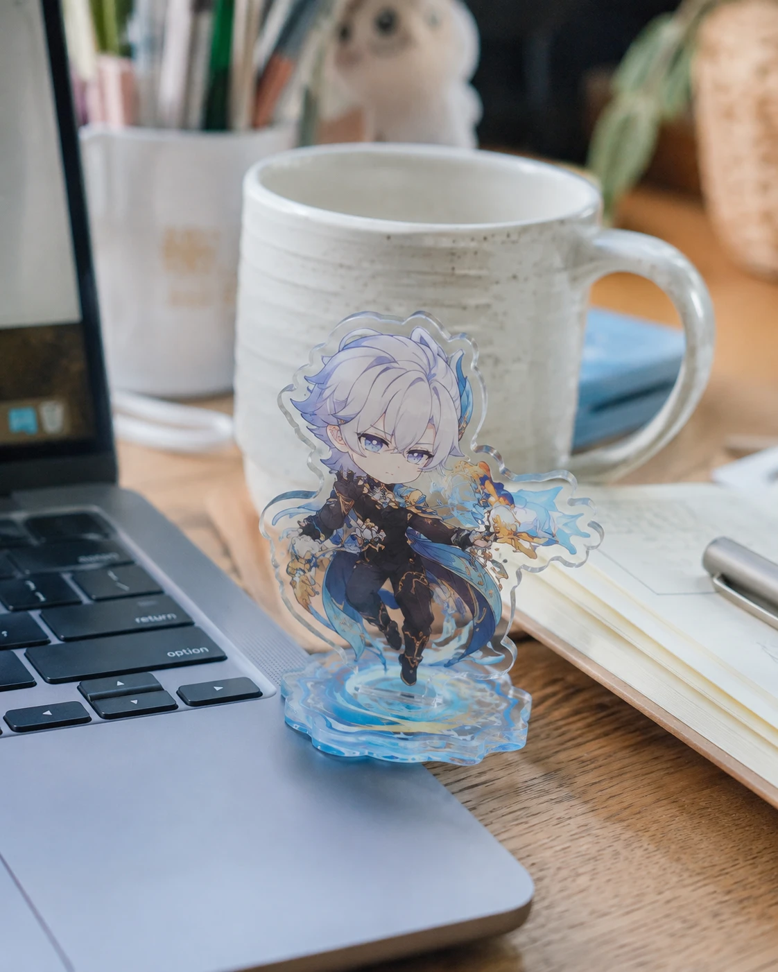 UV printed anime acrylic character standee beside a laptop and coffee mug