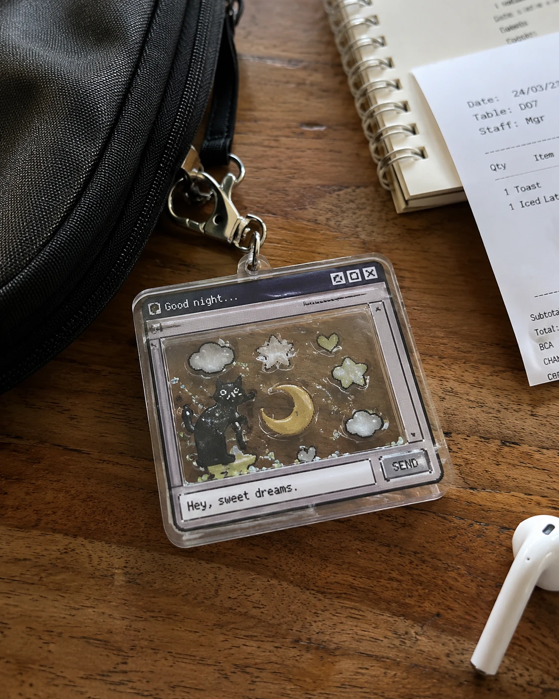 Layered UV printed acrylic shaker keychain displayed on a wooden desk