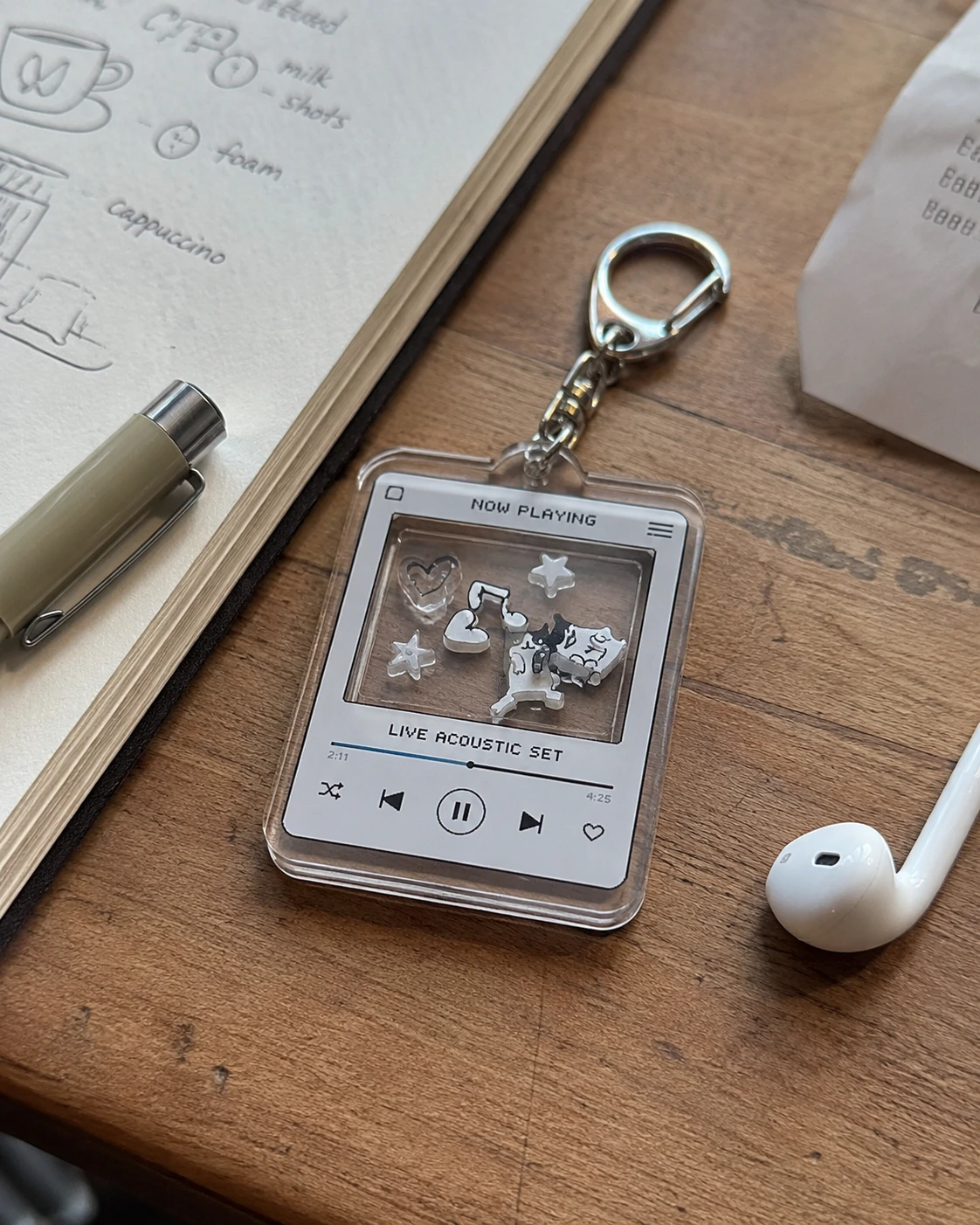 Retro music player UV printed acrylic shaker keychain on a wooden desk