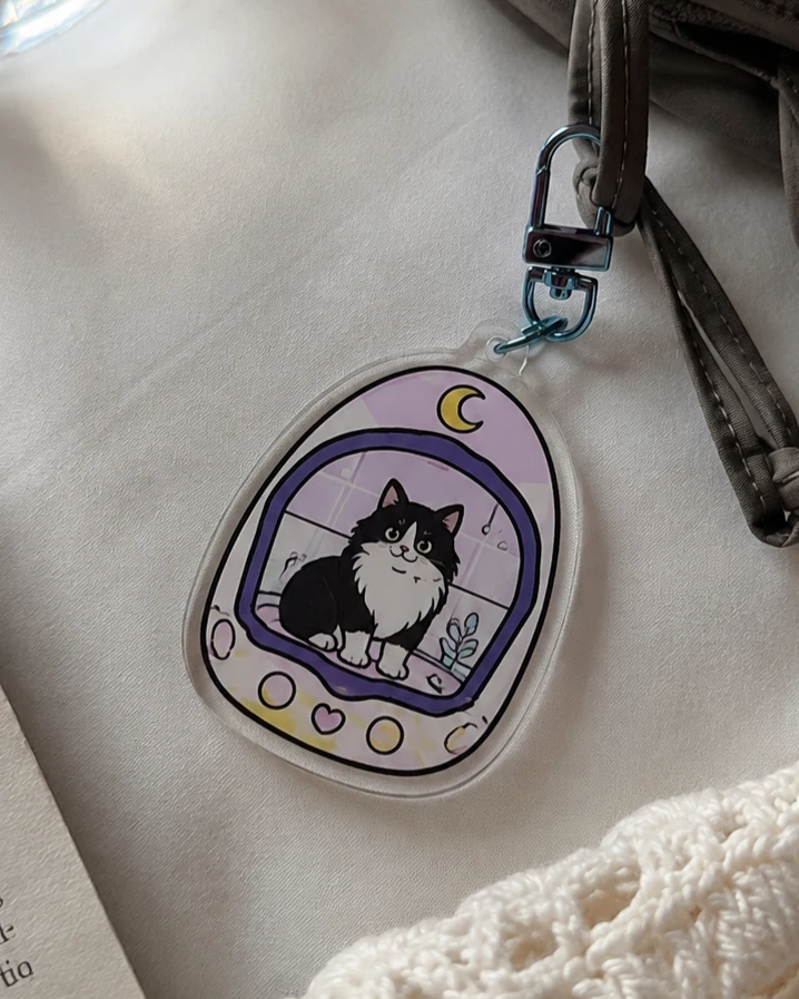 UV printed cat acrylic charm attached to a shoulder bag
