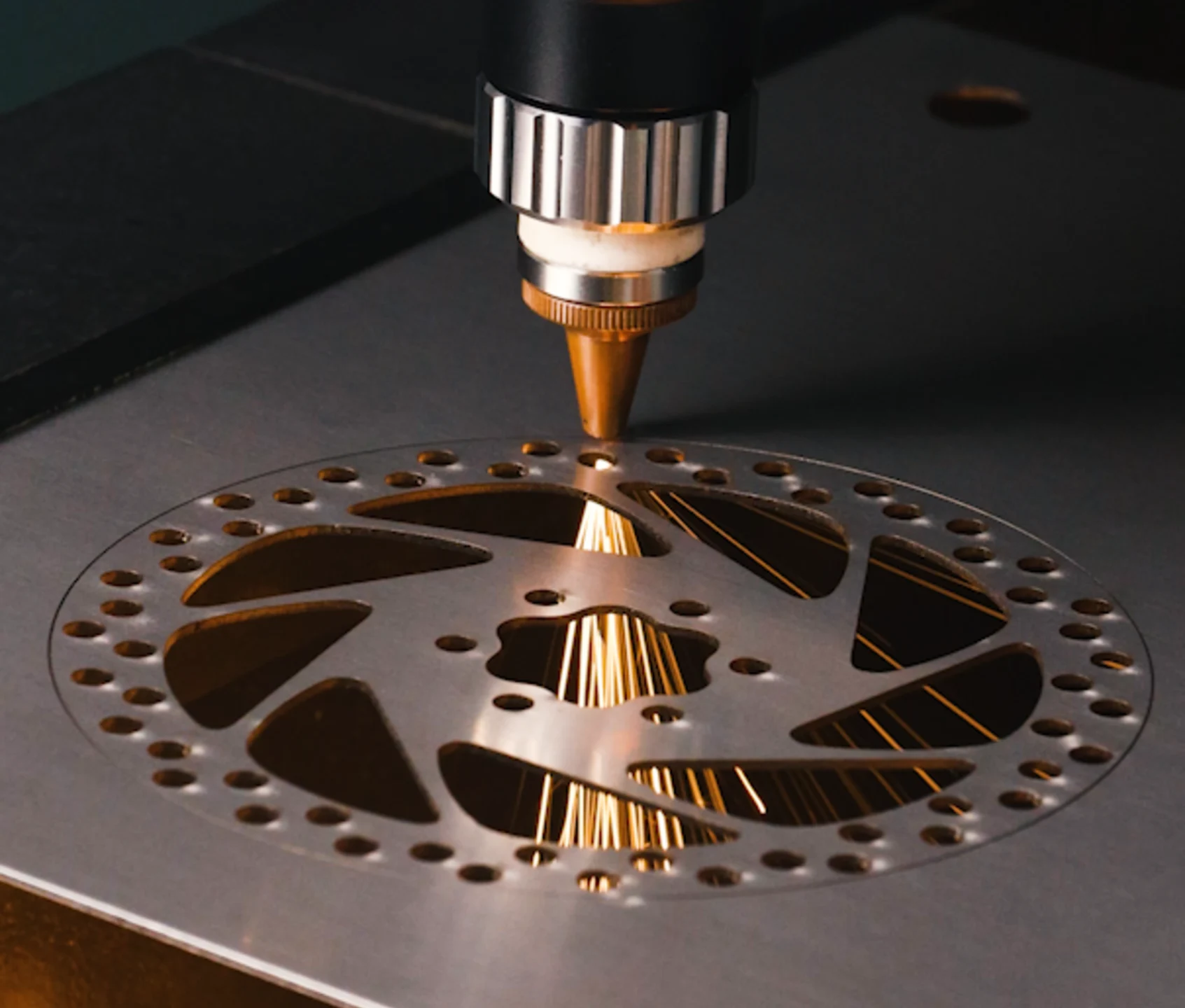 Découpeuse laser à fibre AccuMetal découpant des pièces en acier inoxydable avec une buse propre