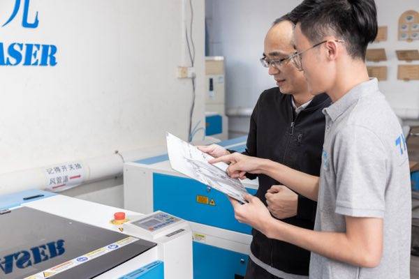 Staff discussing details of samples with customers in front of the equipment.