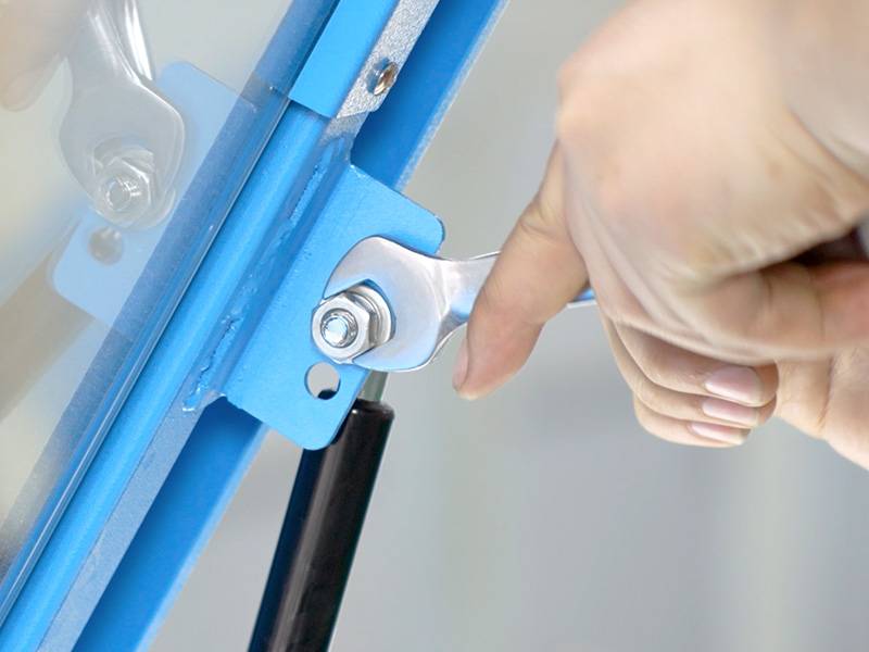 hand tightening a bolt using a small wrench