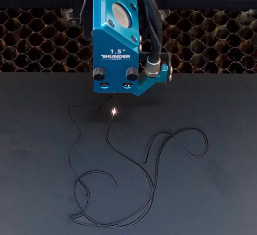 A picture that shows the process of making a laser cut cat decoration.